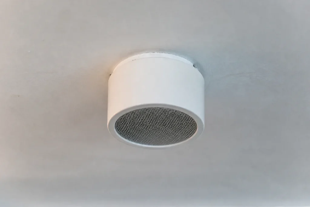 Conduit rond blanc fixe au plafond avec grille metallique