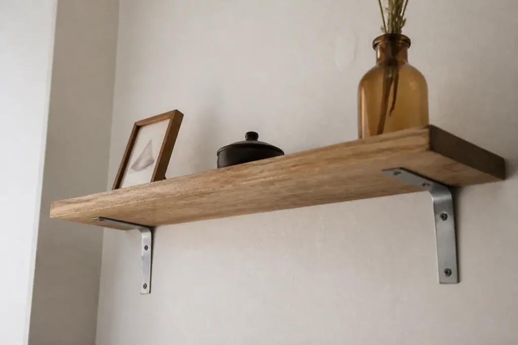 Etagere en bois fixee au mur avec equerres metalliques