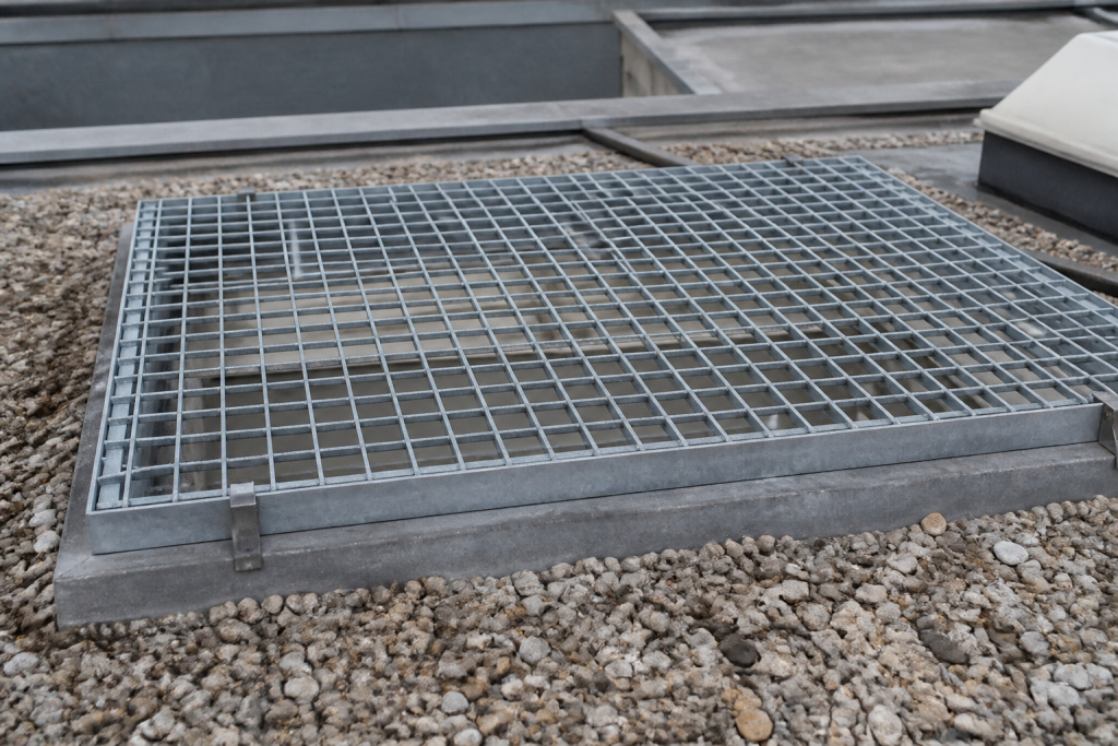 Grille metallique fixee sur une ouverture de toit
