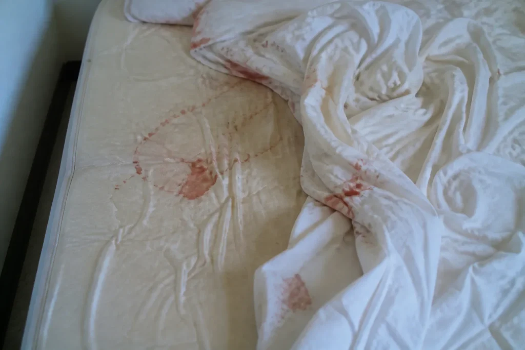 Matelas avec taches de sang sur draps froisses