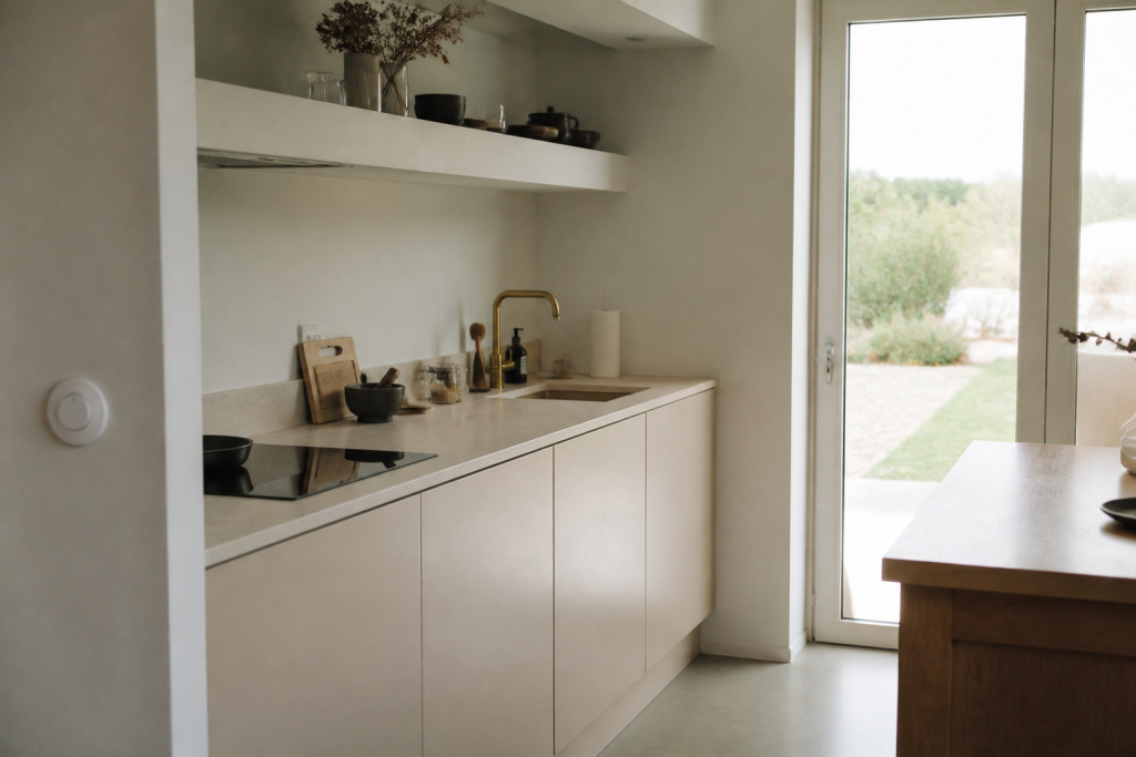 Petite cuisine aux murs clairs et facades sans poignee