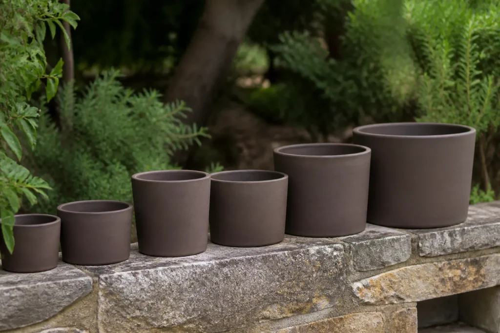 Pots bruns mats alignes sur muret de pierre