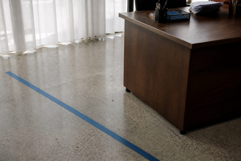 Ruban bleu au sol devant un bureau en bois