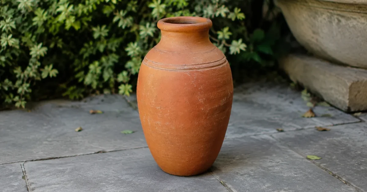 vase en argile rouge debout sur dalles grises