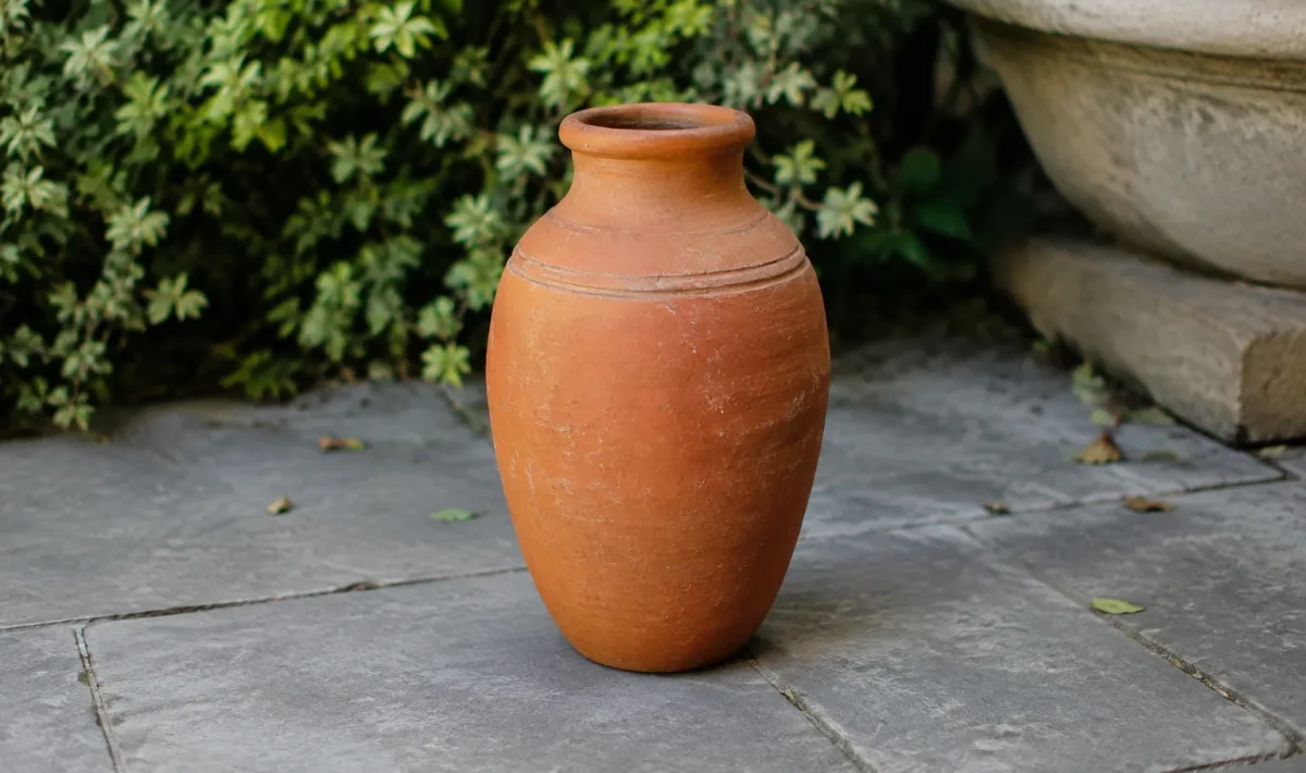 vase en argile rouge debout sur dalles grises