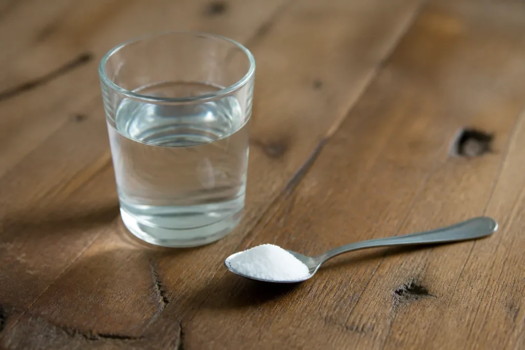 Verre d'eau et cuillère de poudre blanche
